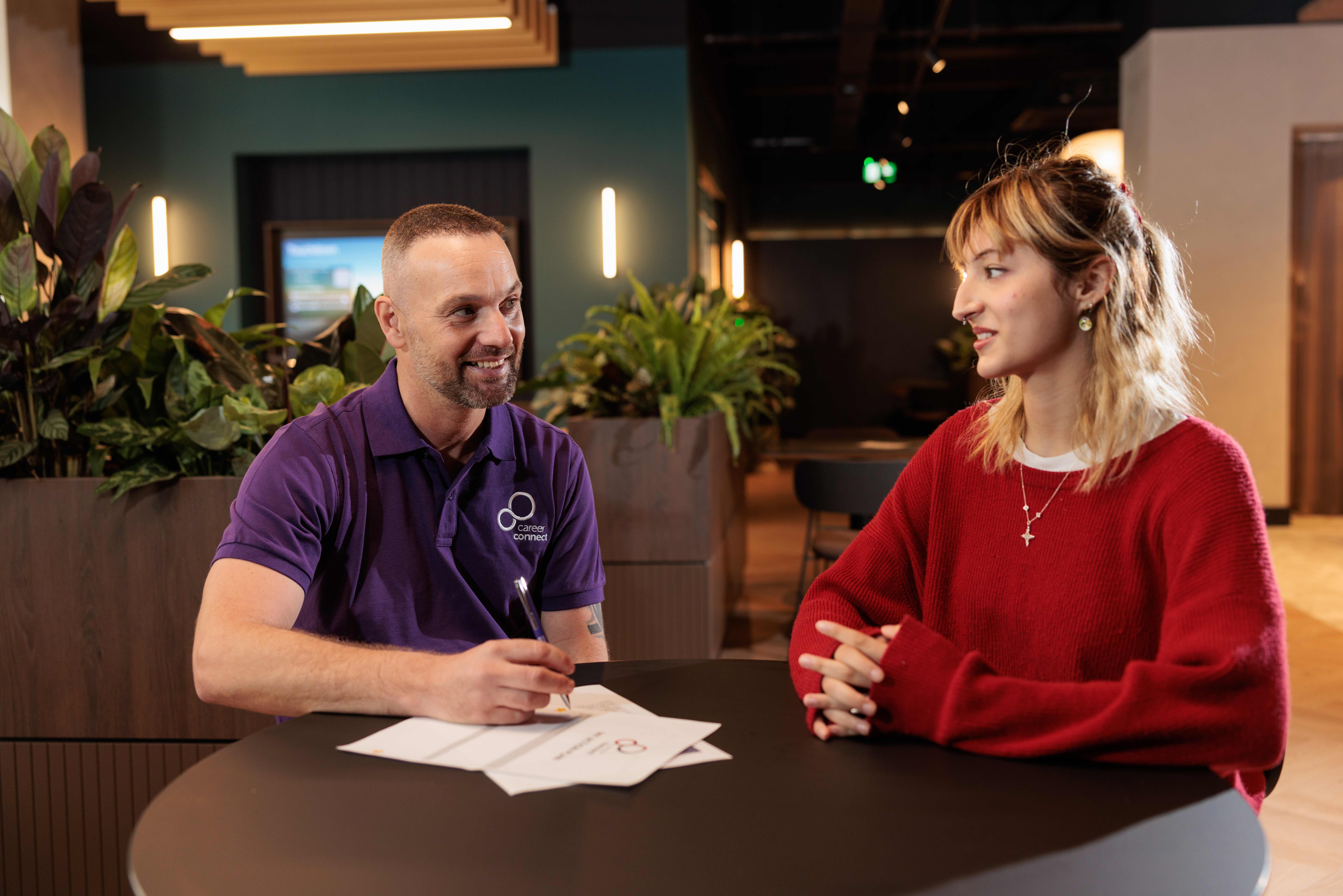 A male careers adviser giving advice to a young woman.